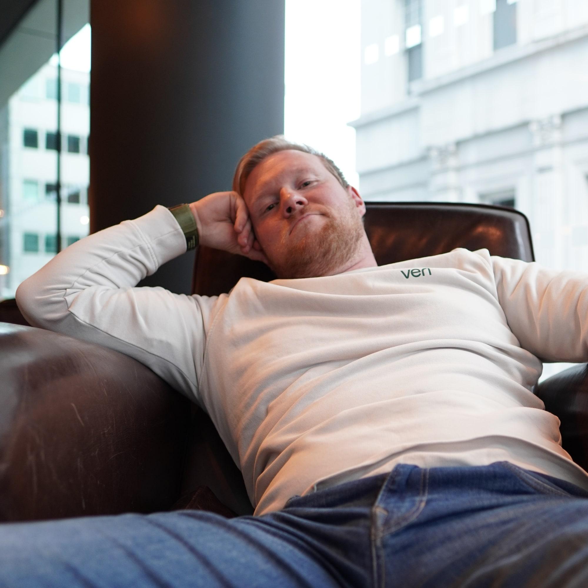 Perttu Lähteenlahti sitting in a leather armchair by a window